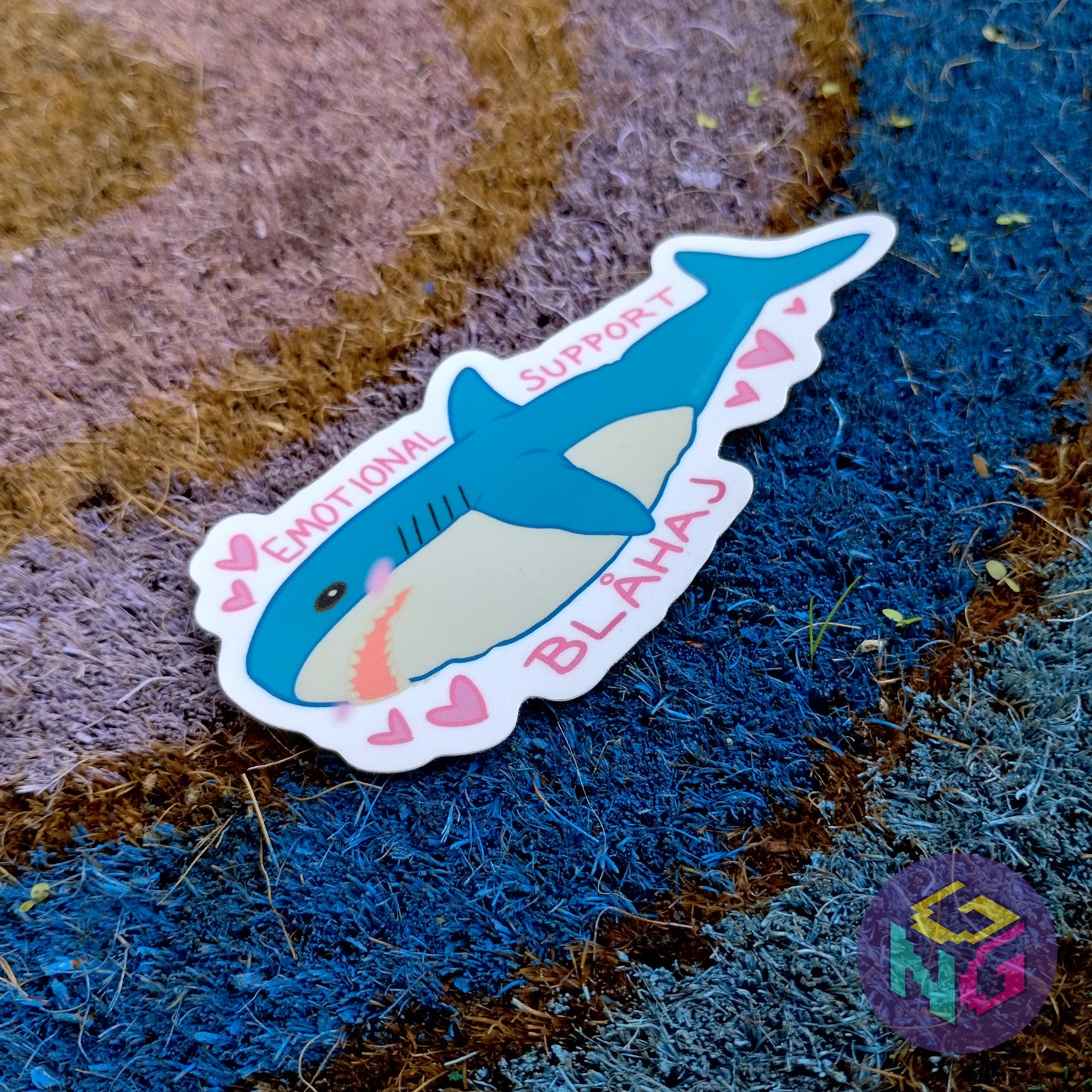 ikea blahaj sticker lying at an angle on the rainbow welcome mat