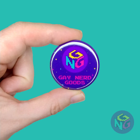 light skinned hand holding 1.5" round purple logo pinback button with gay nerd goods logo against mint background
