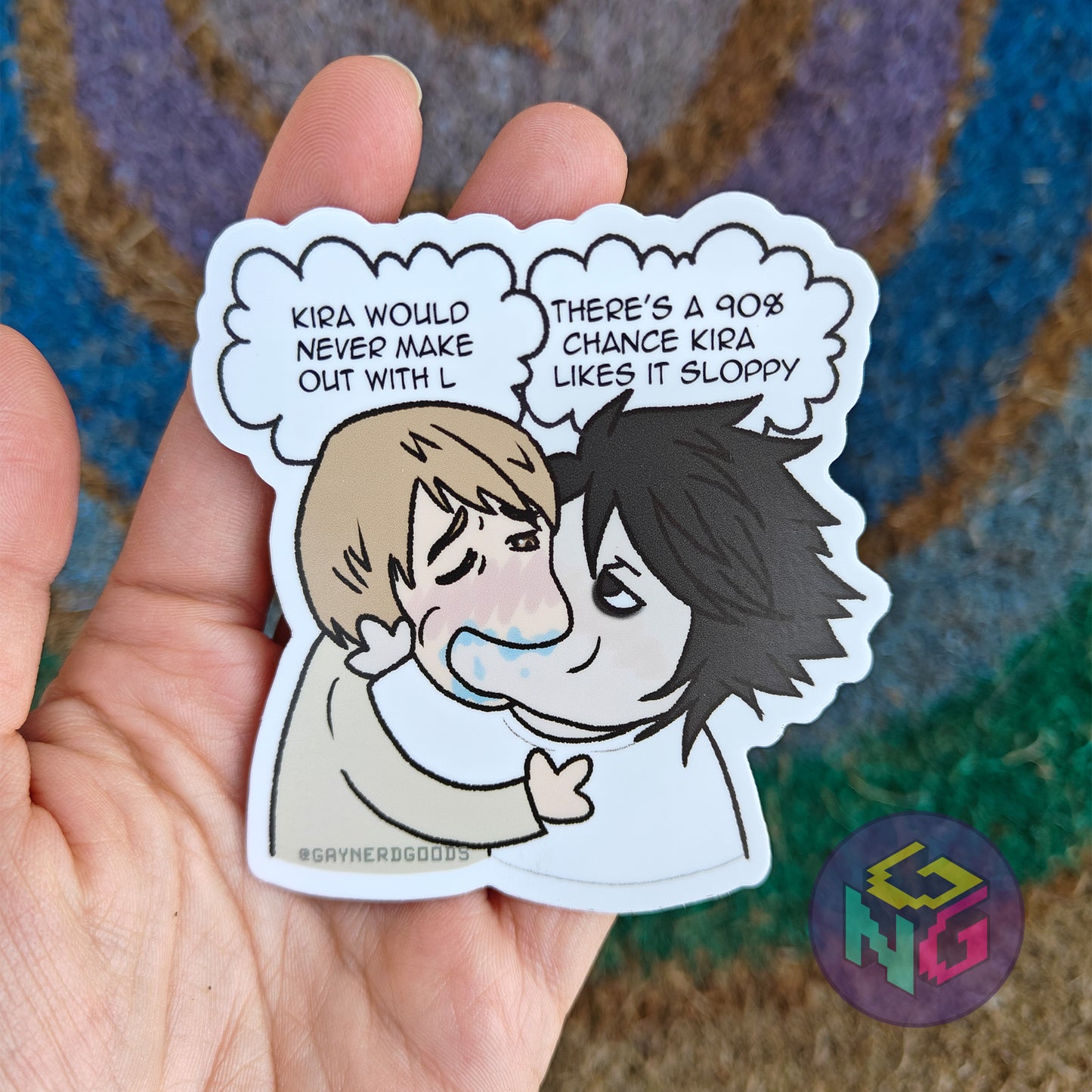 light kissing l gay death note sticker in a palm in front of a rainbow and neutral background