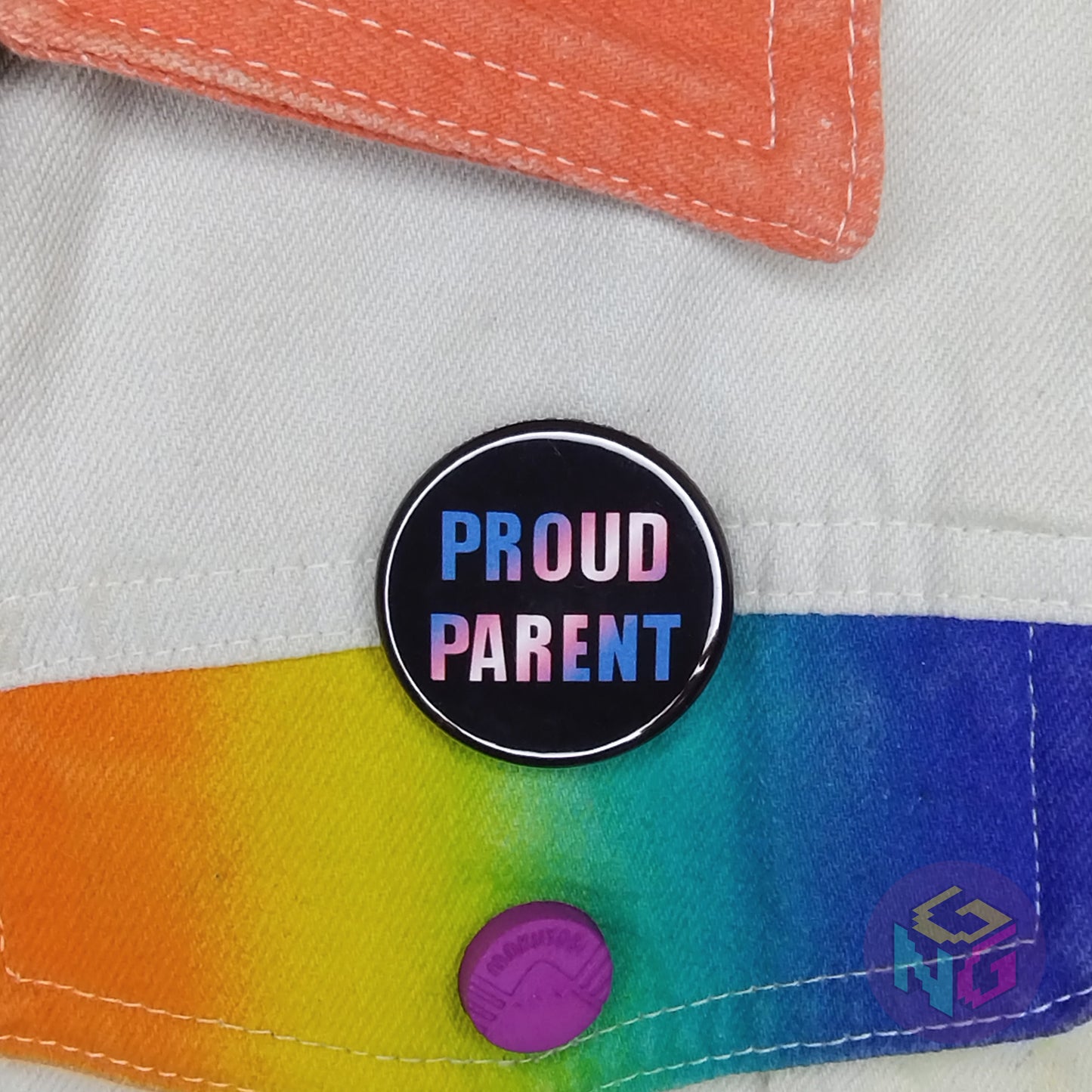 parent of transgender kid pride pin pinned to a white denim jacket with rainbow details
