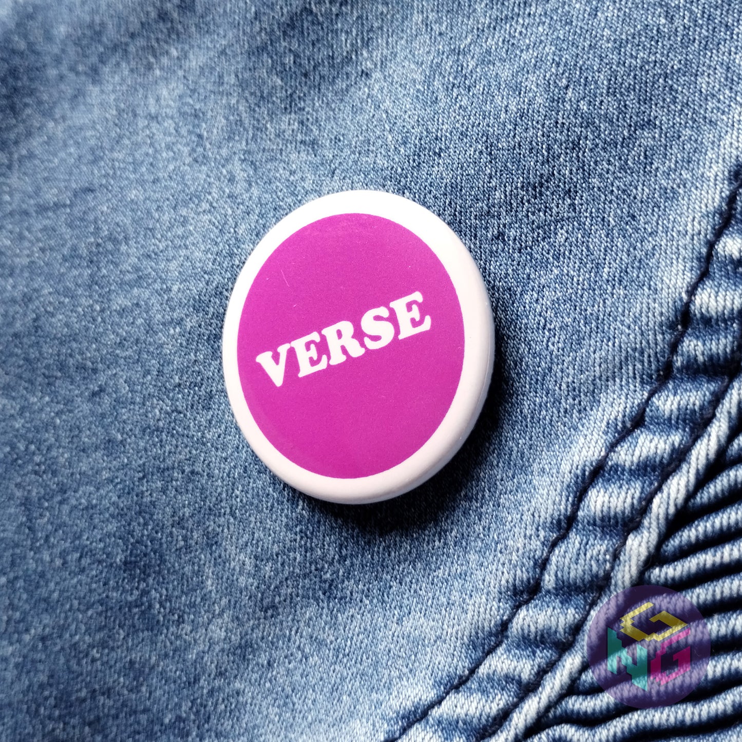 purple round verse button on a denim background