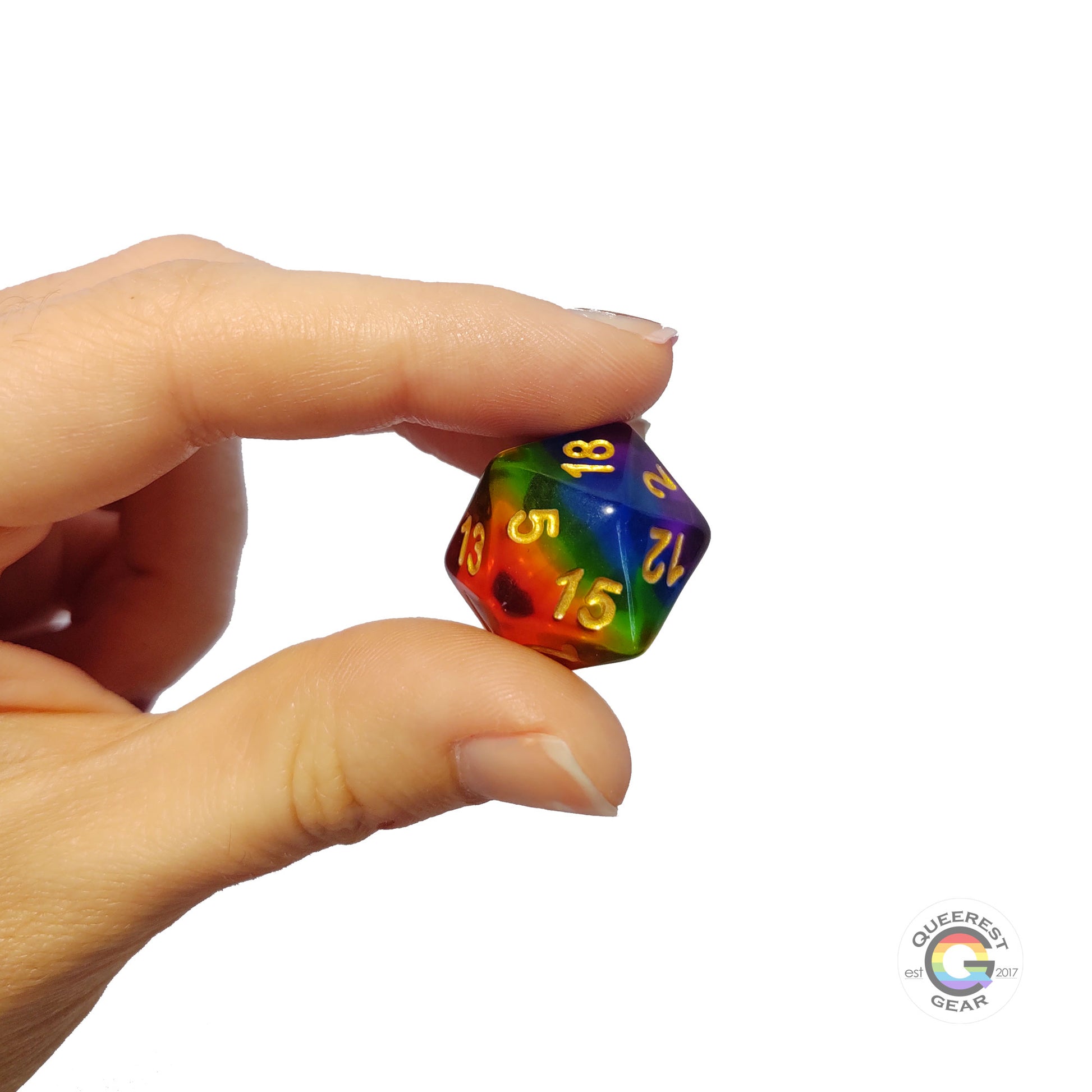 A hand holding up the rainbow d20 to show off the color and transparency