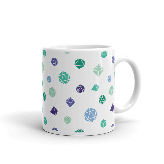 white mug on a white background with handle facing right. It has an all-over print of polyhedral d&d dice in the gay mlm colors of greens and blues