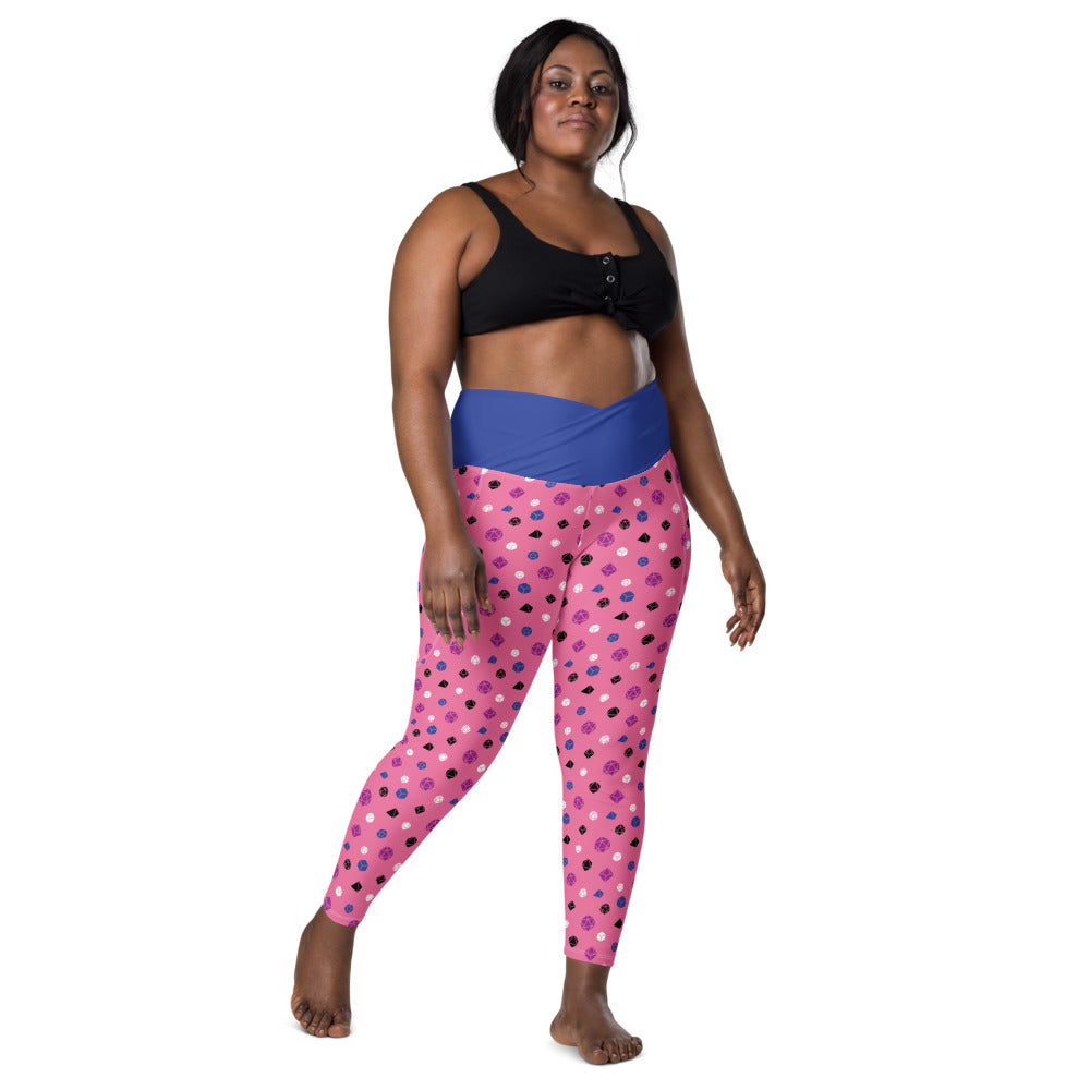 front view of dark-skinned female-presenting plus size model wearing the genderfluid dice leggings and a black sports bra. This view shows off the blue crossover high-rise waistband