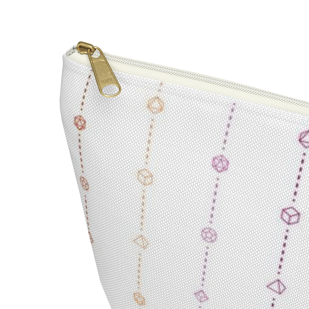 the large lesbian dice t-bottom pouch corner detail on a white background. it's white with pink and orange stripes of dashed lines and polyhedral dice and a gold zipper pull