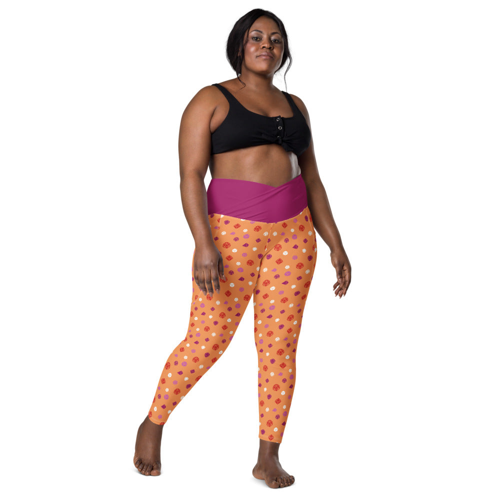 front view of dark-skinned female-presenting plus size model wearing the lesbian dice leggings and a black sports bra. This view shows off the pink crossover high-rise waistband