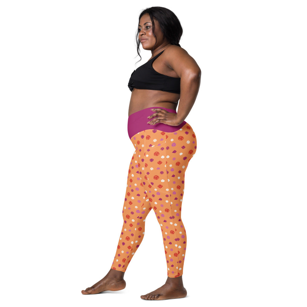 Left side view of dark-skinned female-presenting model wearing the lesbian dice leggings and black sports bra. She is facing left with her left hand on her hip and right leg forward