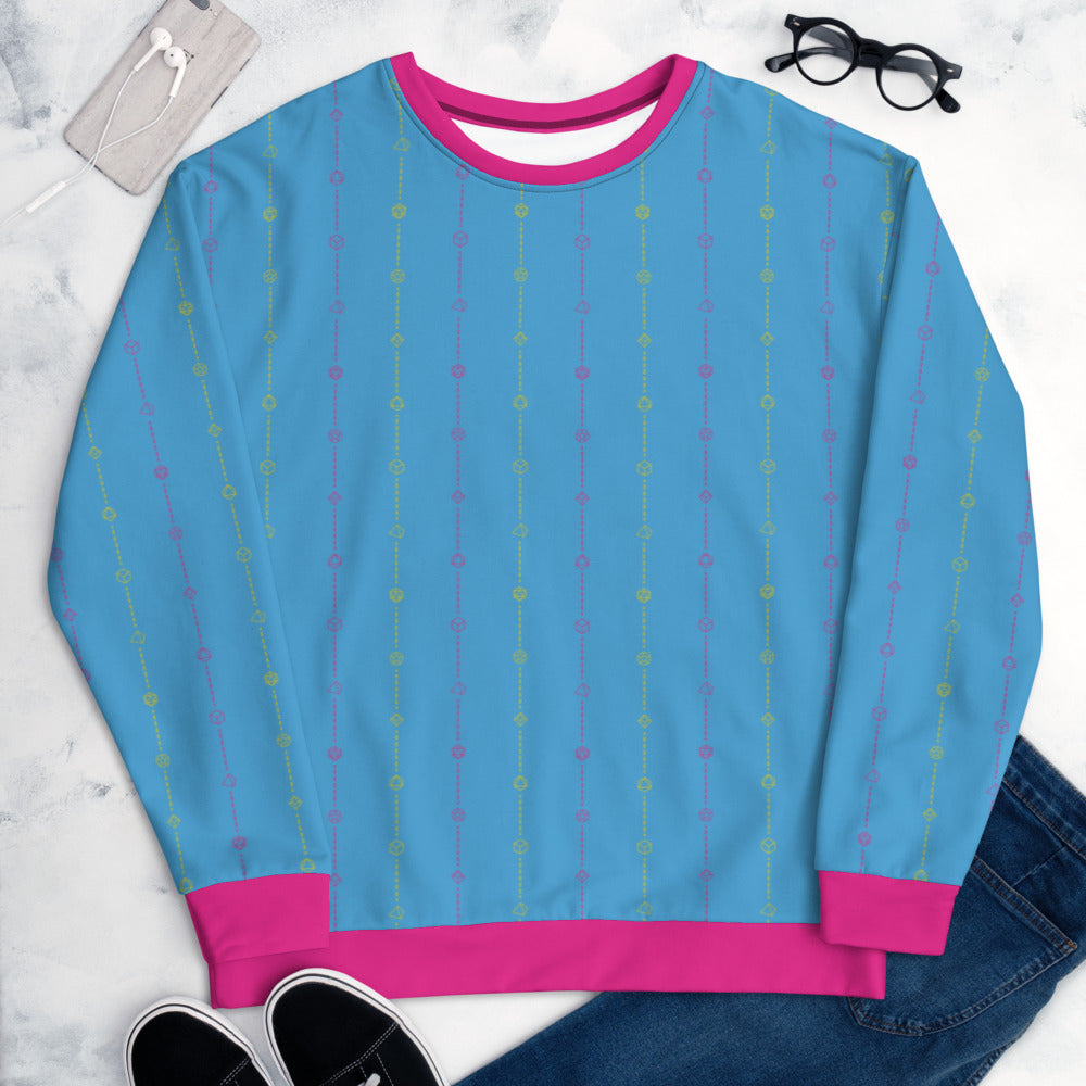 The pansexual pride sweater laying flat, surrounded by clothes, a phone, and glasses. the sweater is blue and has stripes of dashed lines and polyhedral dnd dice in pink and yellow. The cuffs, collar, and waistband are a matching pink