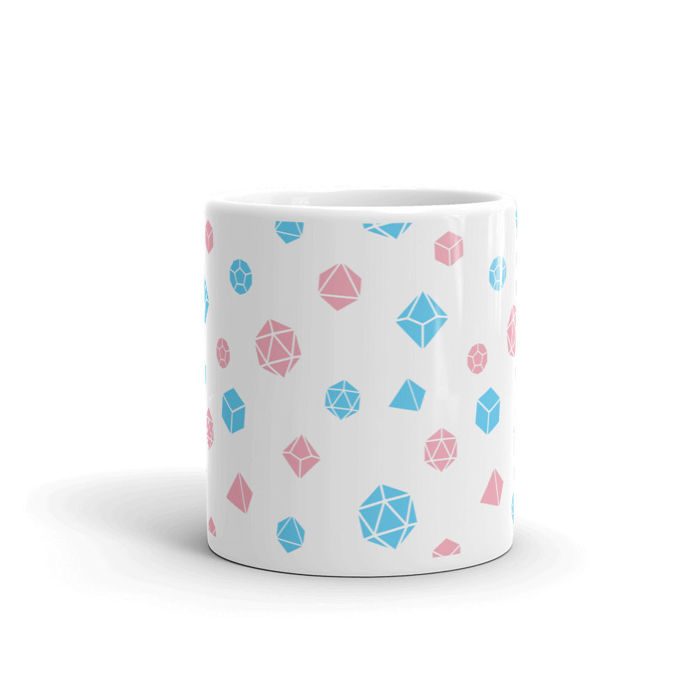 white mug on a white background with handle facing back. It has an all-over print of polyhedral d&d dice in the transgender colors of pink and blue
