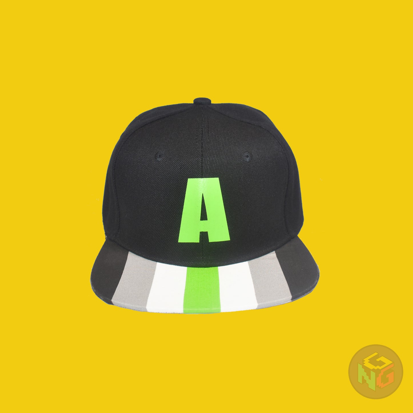 Black flat bill snapback hat. The brim has the agender pride flag on both sides and the front of the hat has a green letter “A”. Front view