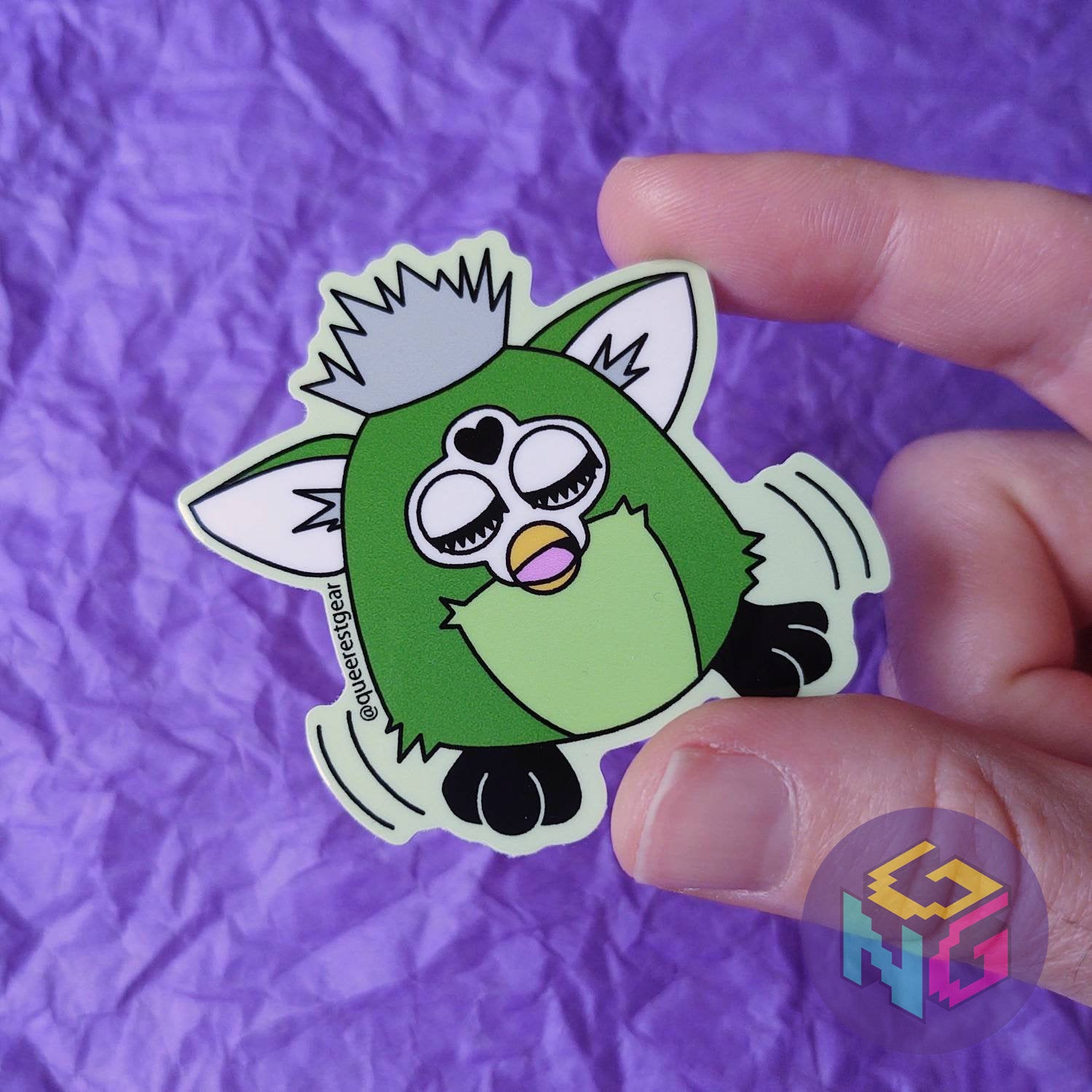 green aromantic pride furby sticker doing a dance in front of a purple background
