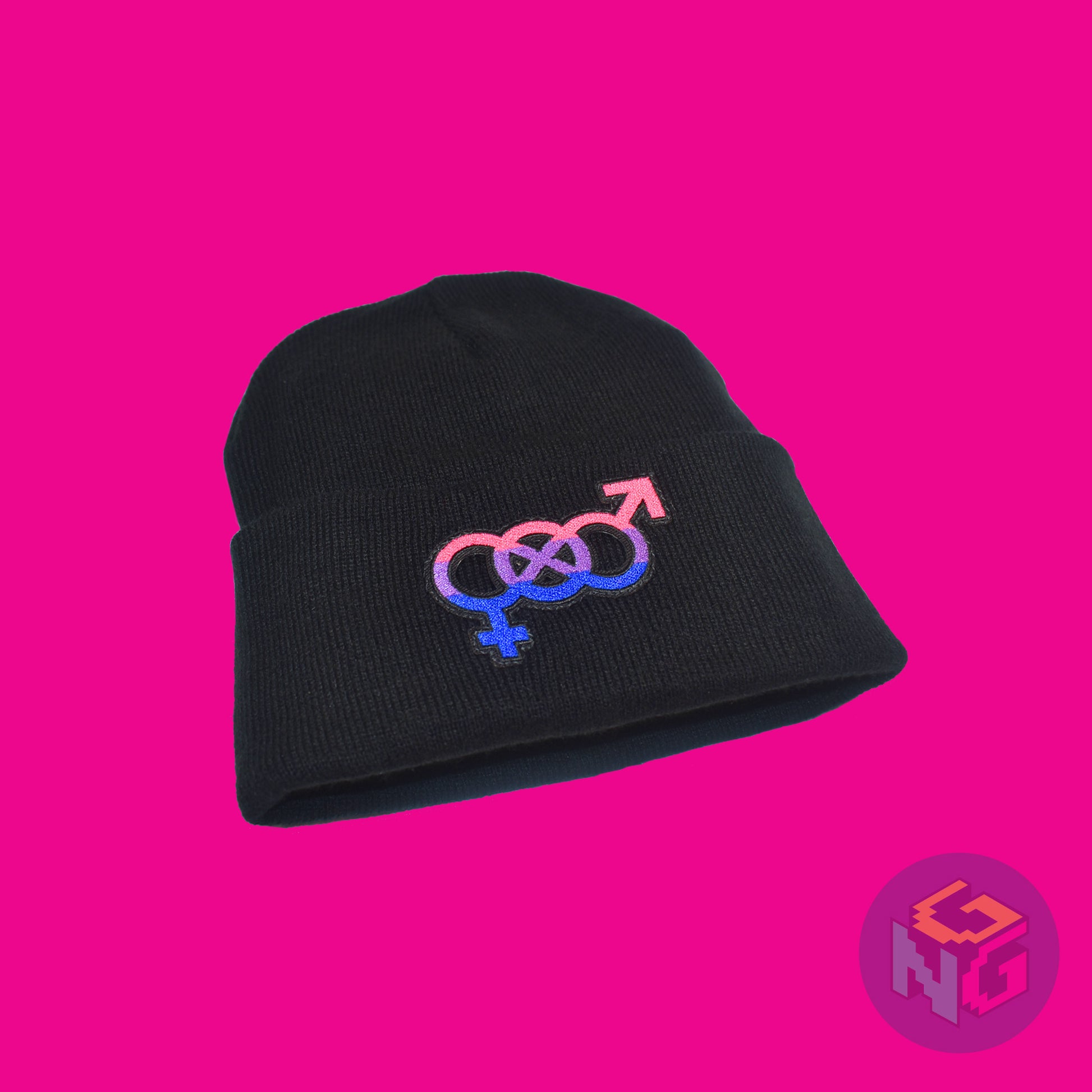 Black knit fabric beanie with the bisexual symbol in asexual pink, purple, and blue on the front. It is laying flat and seen at a low left angle on pink background