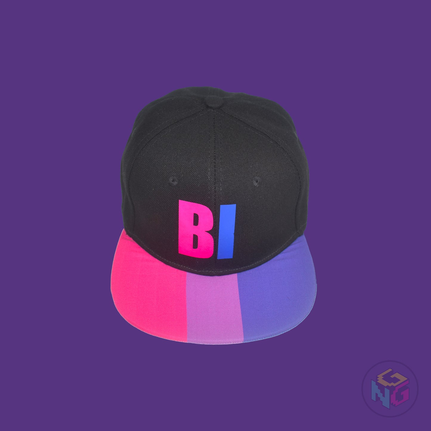 Black flat bill snapback hat. The brim has the bisexual pride flag on both sides and the front of the hat has the word “BI” in pink and blue. Front top view