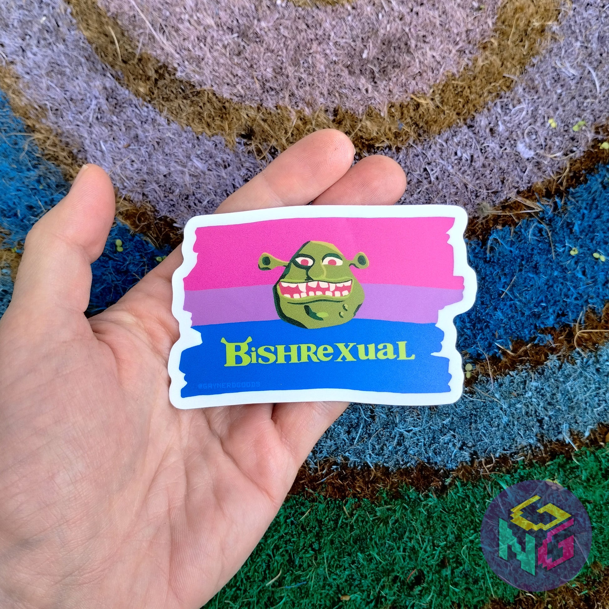 matter bishrexual sticker held in a hand in front of the rainbow welcome mat