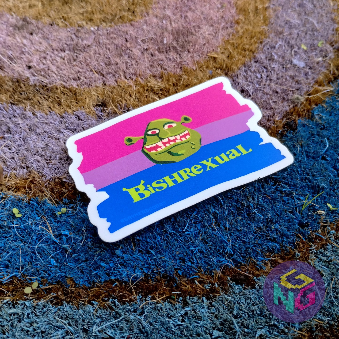 bishrexual sticker lying at an angle on top of the rainbow welcome mat