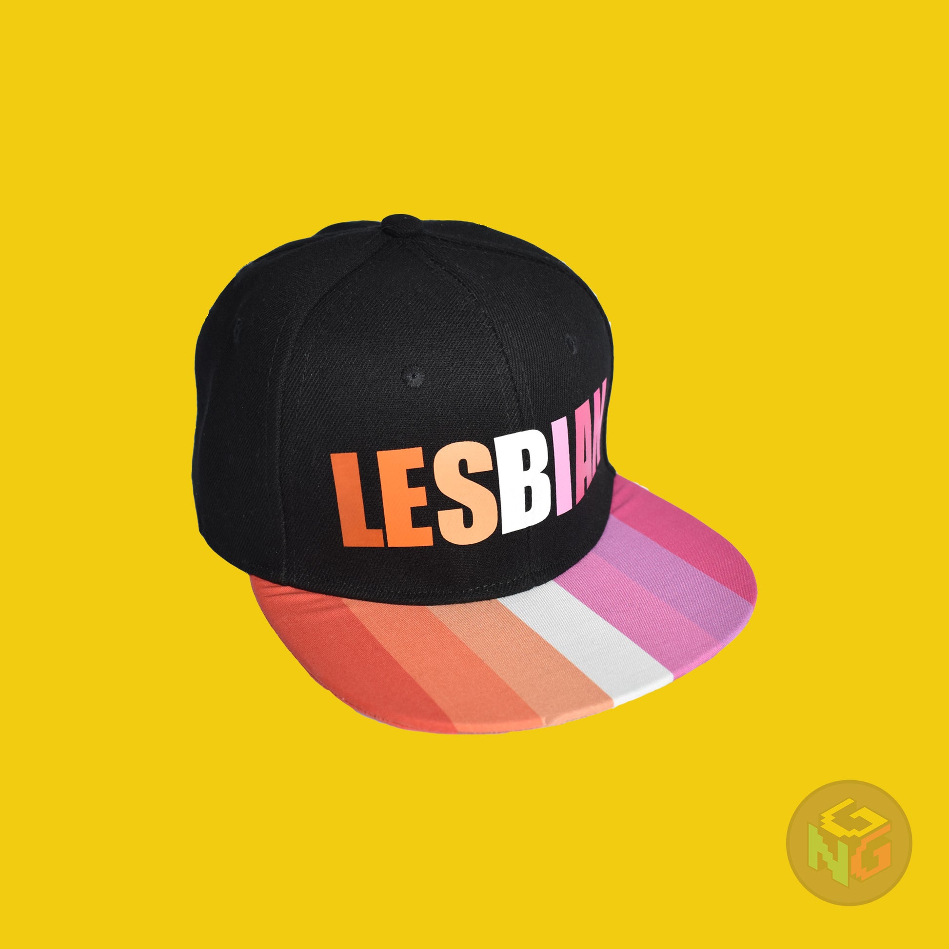Black flat bill snapback hat. The brim has the lesbian pride flag on both sides and the front of the hat has the word “LESBIAN” in orange, pink, and white letters. Front right view