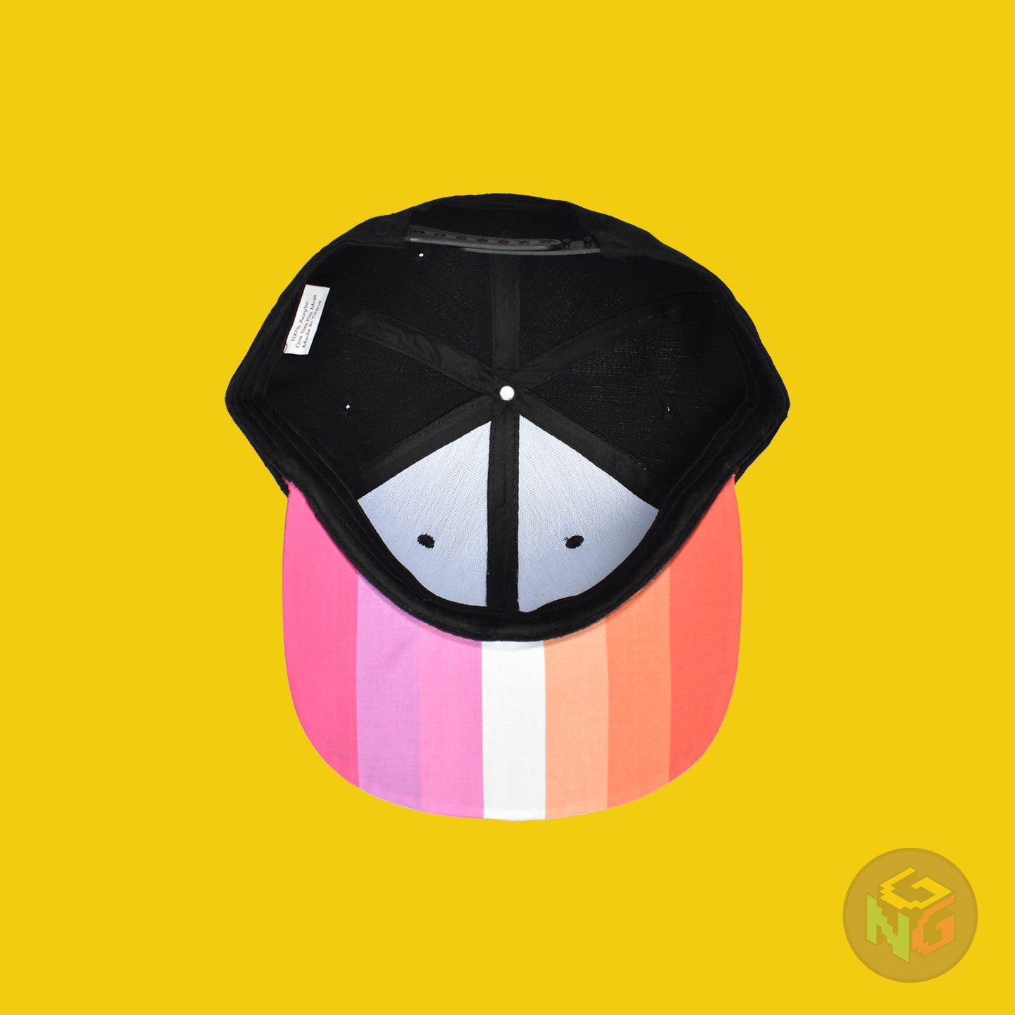 Black flat bill snapback hat. The brim has the lesbian pride flag on both sides and the front of the hat has the word “LESBIAN” in orange, pink, and white letters. Underside view