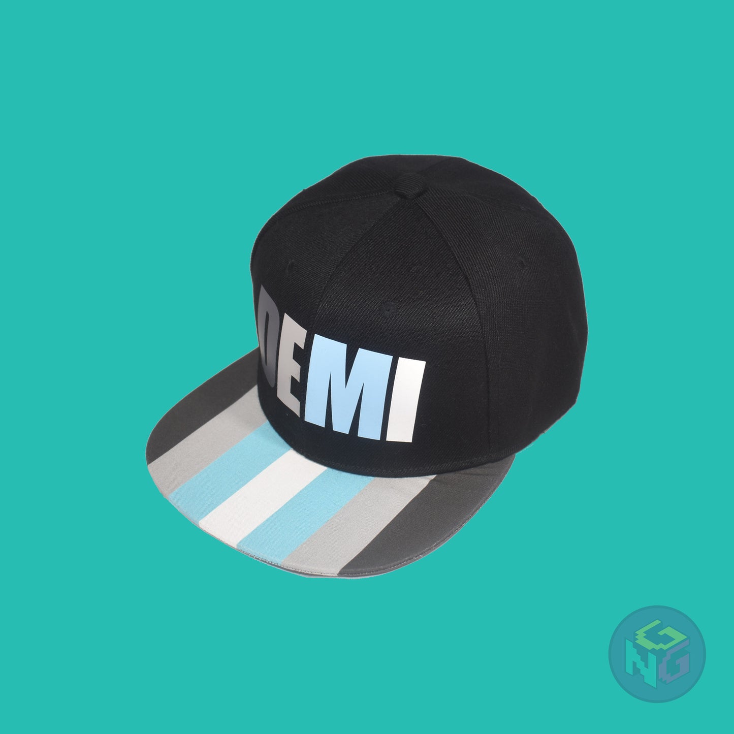 Black flat bill snapback hat. The brim has the demiboy pride flag on both sides and the front of the hat has the word “DEMI” in dark grey, light grey, blue, and white. Front left view