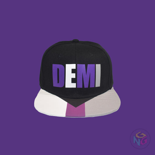 Black flat bill snapback hat. The brim has the demisexual pride flag on both sides and the front of the hat has the word “DEMI” in purple, white, and grey. Front view