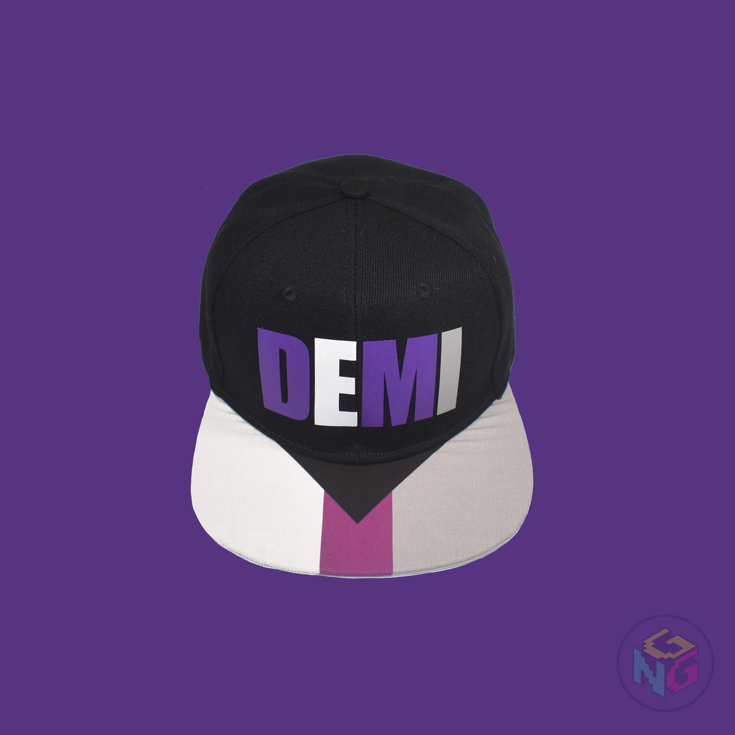 Black flat bill snapback hat. The brim has the demisexual pride flag on both sides and the front of the hat has the word “DEMI” in purple, white, and grey. Front top view