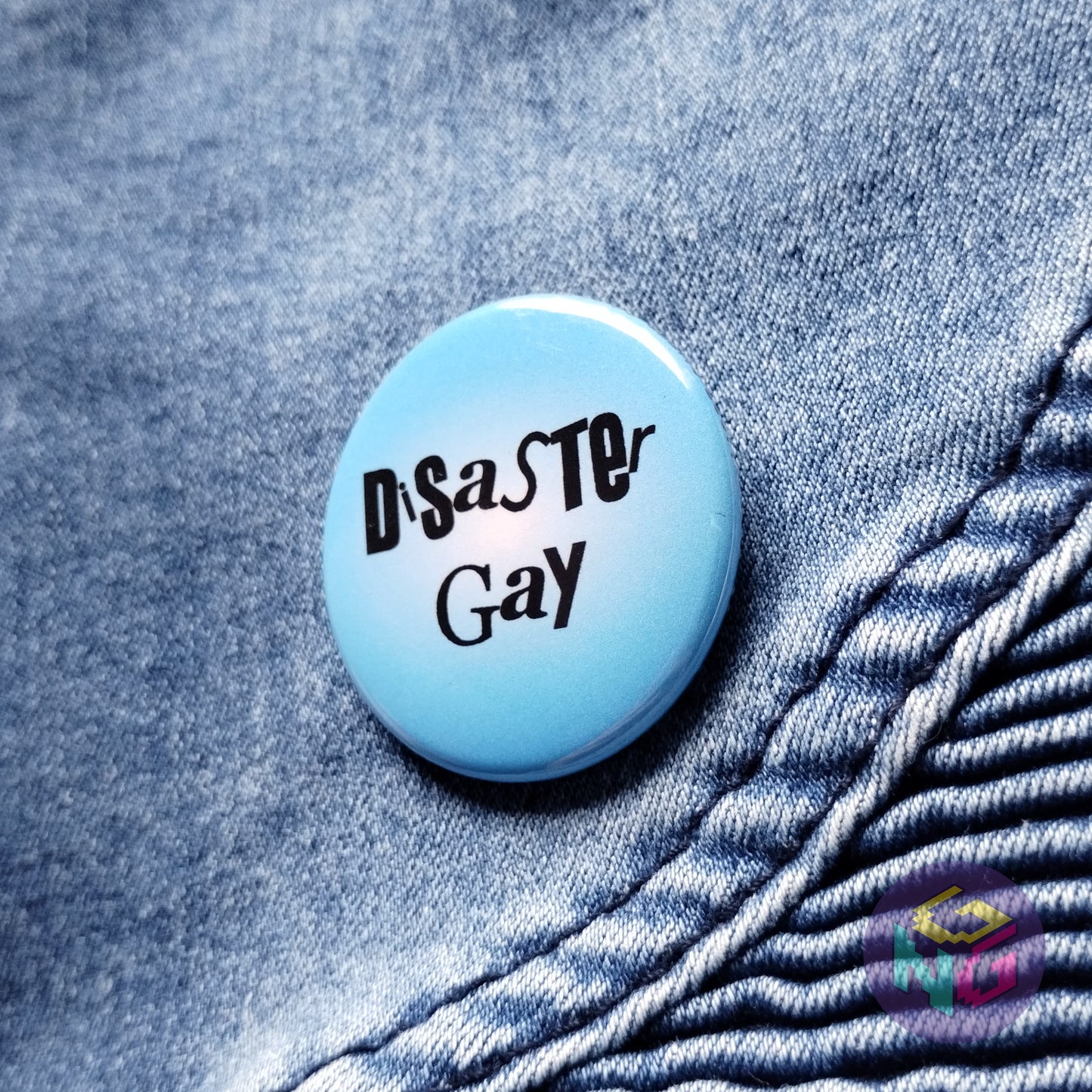disaster gay pin on denim background