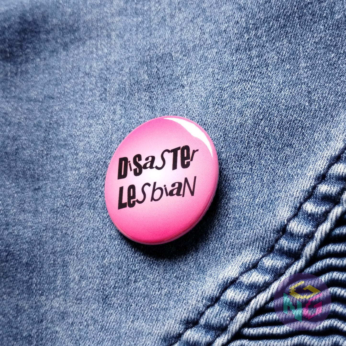 pink disaster lesbian pin on blue denim background