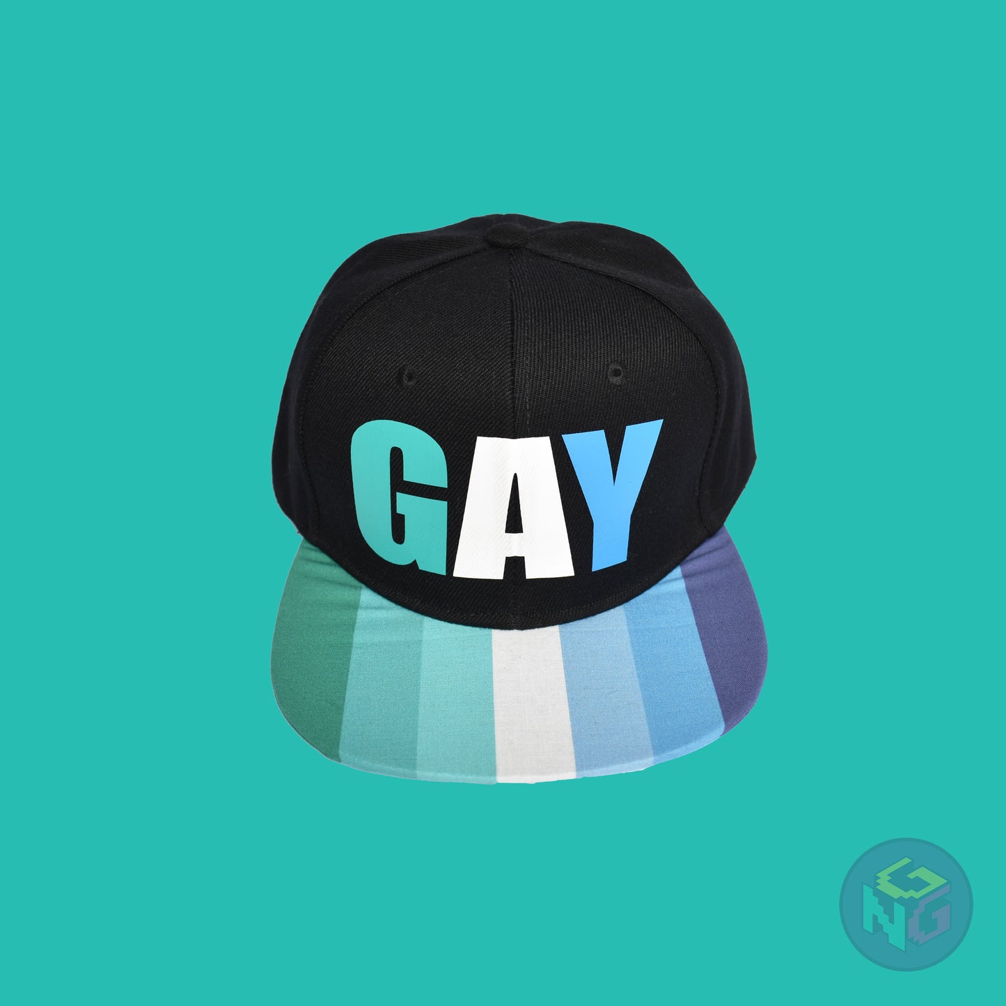 Black flat bill snapback hat. The brim has the gay pride flag on both sides and the front of the hat has the word “GAY” in turquoises, blues, and white. Front top view