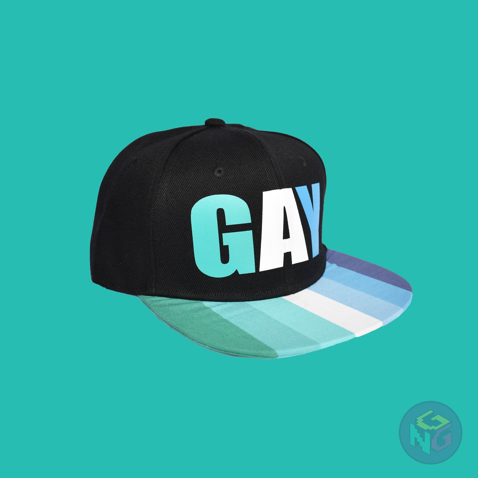 Black flat bill snapback hat. The brim has the gay pride flag on both sides and the front of the hat has the word “GAY” in turquoises, blues, and white. Front right view