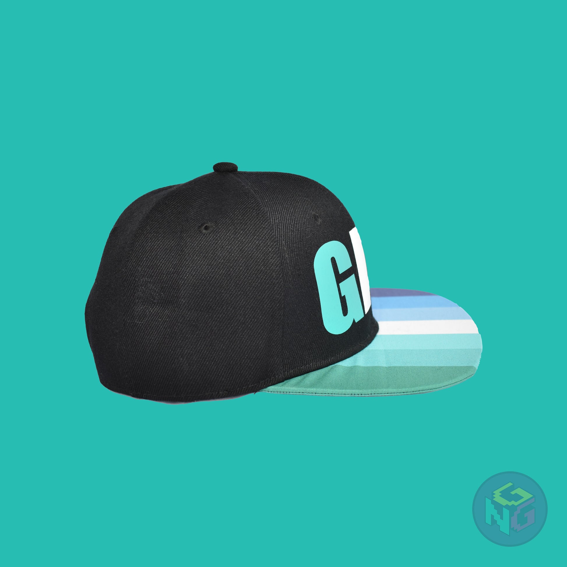 Black flat bill snapback hat. The brim has the gay pride flag on both sides and the front of the hat has the word “GAY” in turquoises, blues, and white. Right view