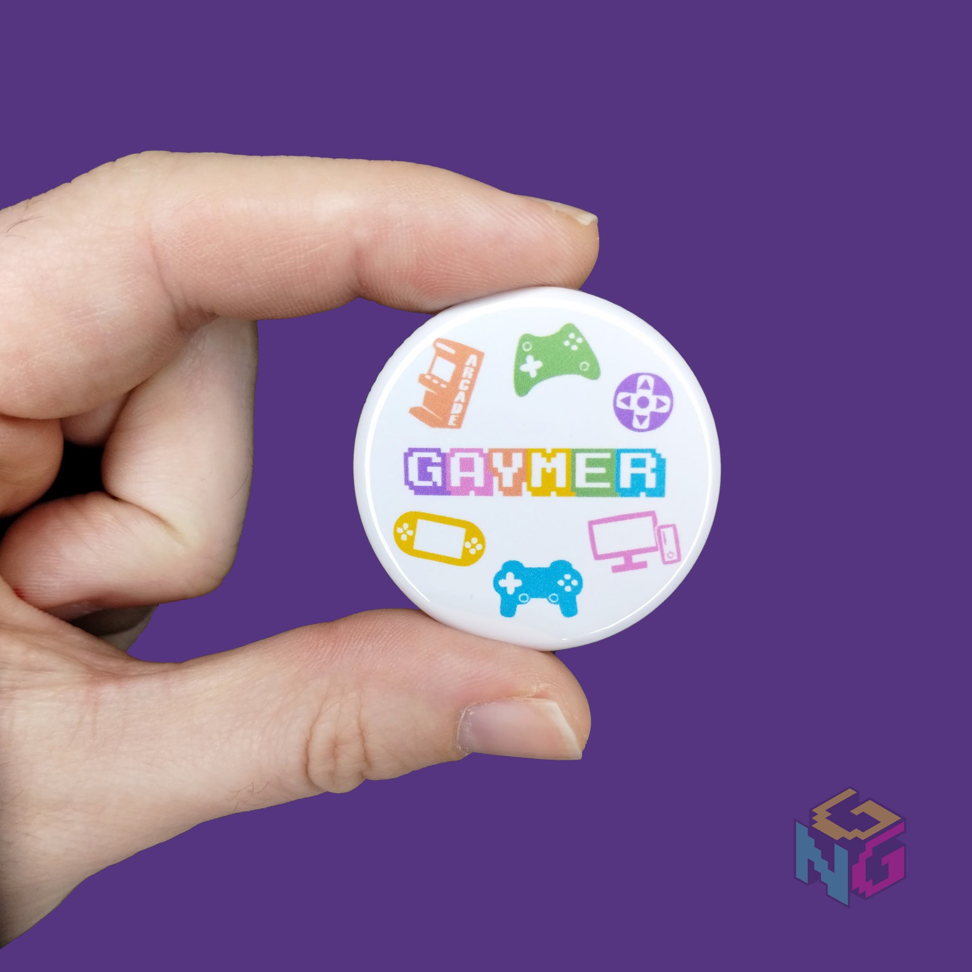 light skinned hand holding small round gaymer button on purple background