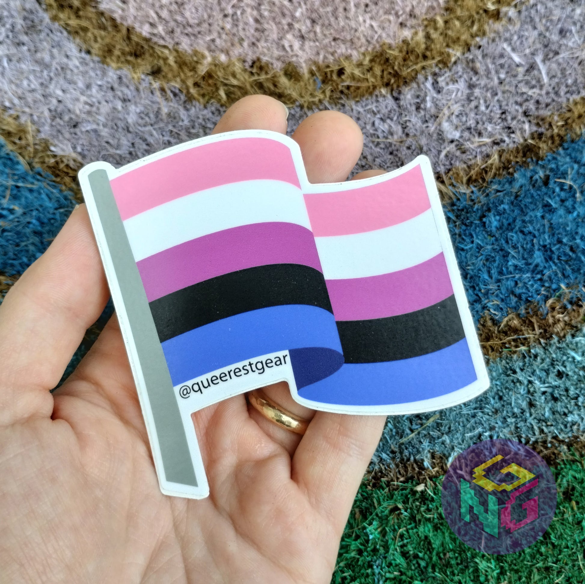 genderfluid flag vinyl sticker held in hand in front of rainbow welcome mat