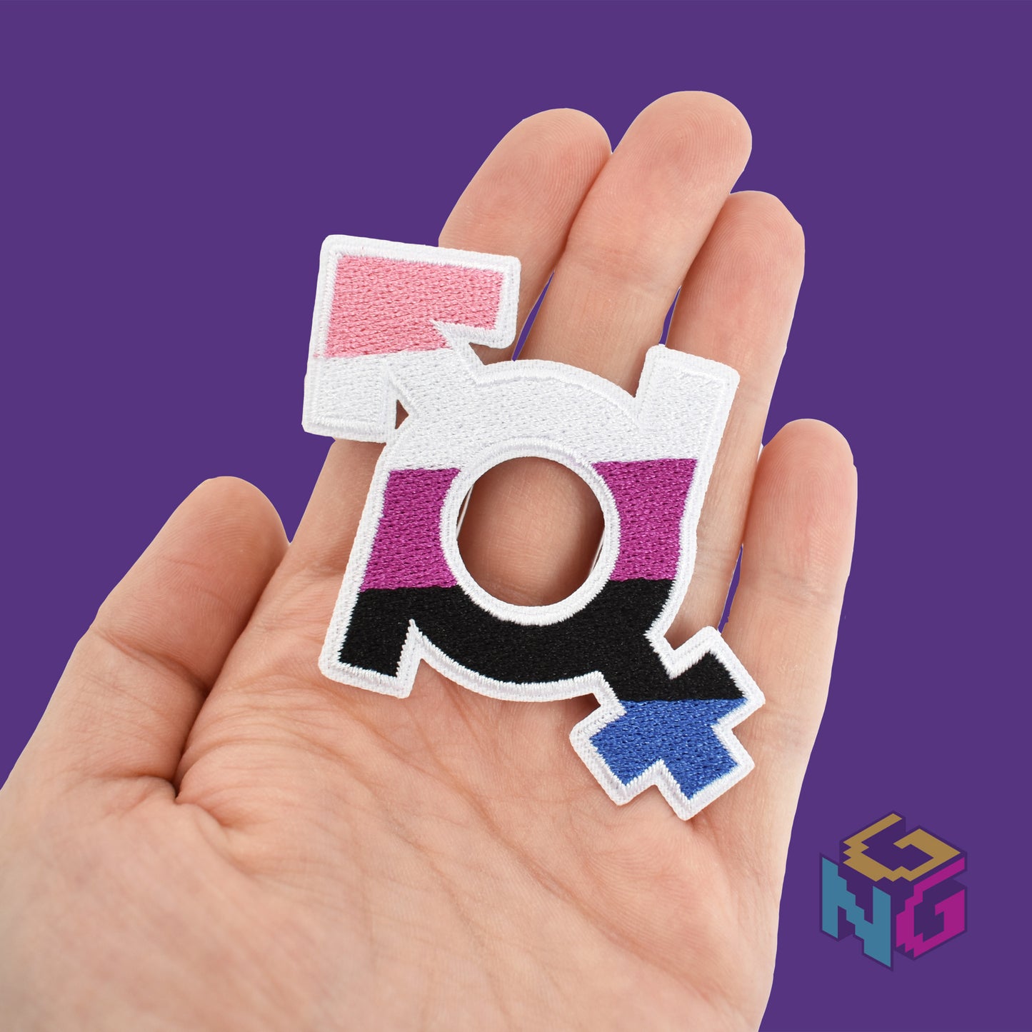 genderfluid iron on patch held in hand in front of purple background