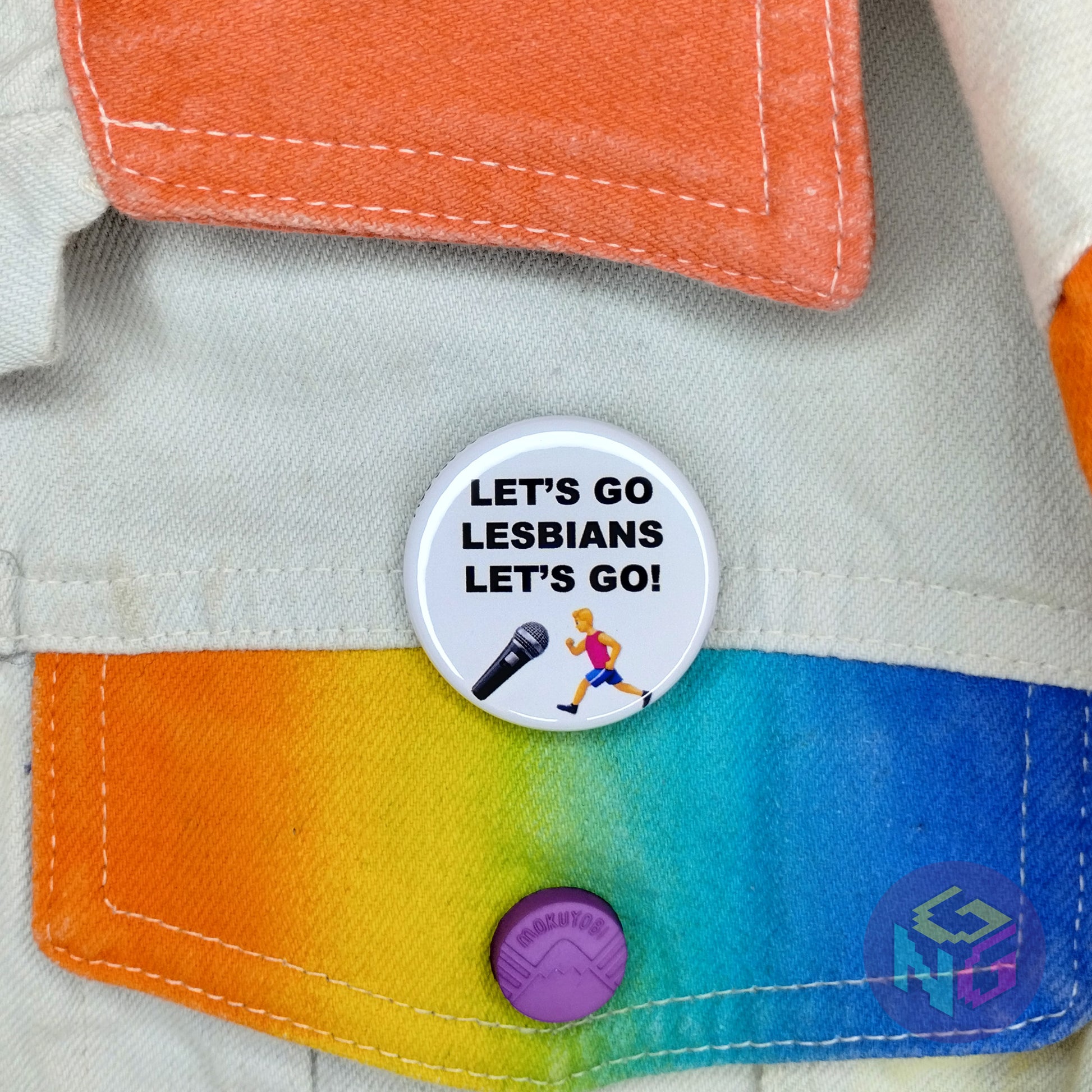 round lesbian pride billy on the street button pinned to a white denim jacket that has rainbow details
