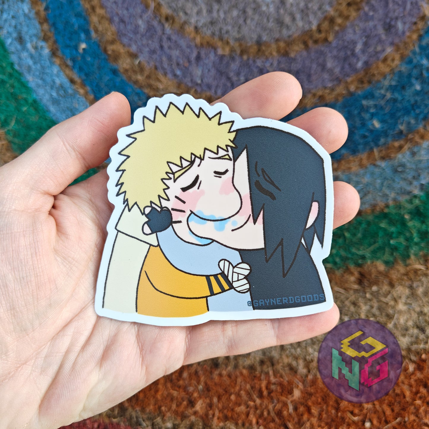 sasuke and naruto sasunaru making out vinyl sticker kiss meme being held in front of a rainbow