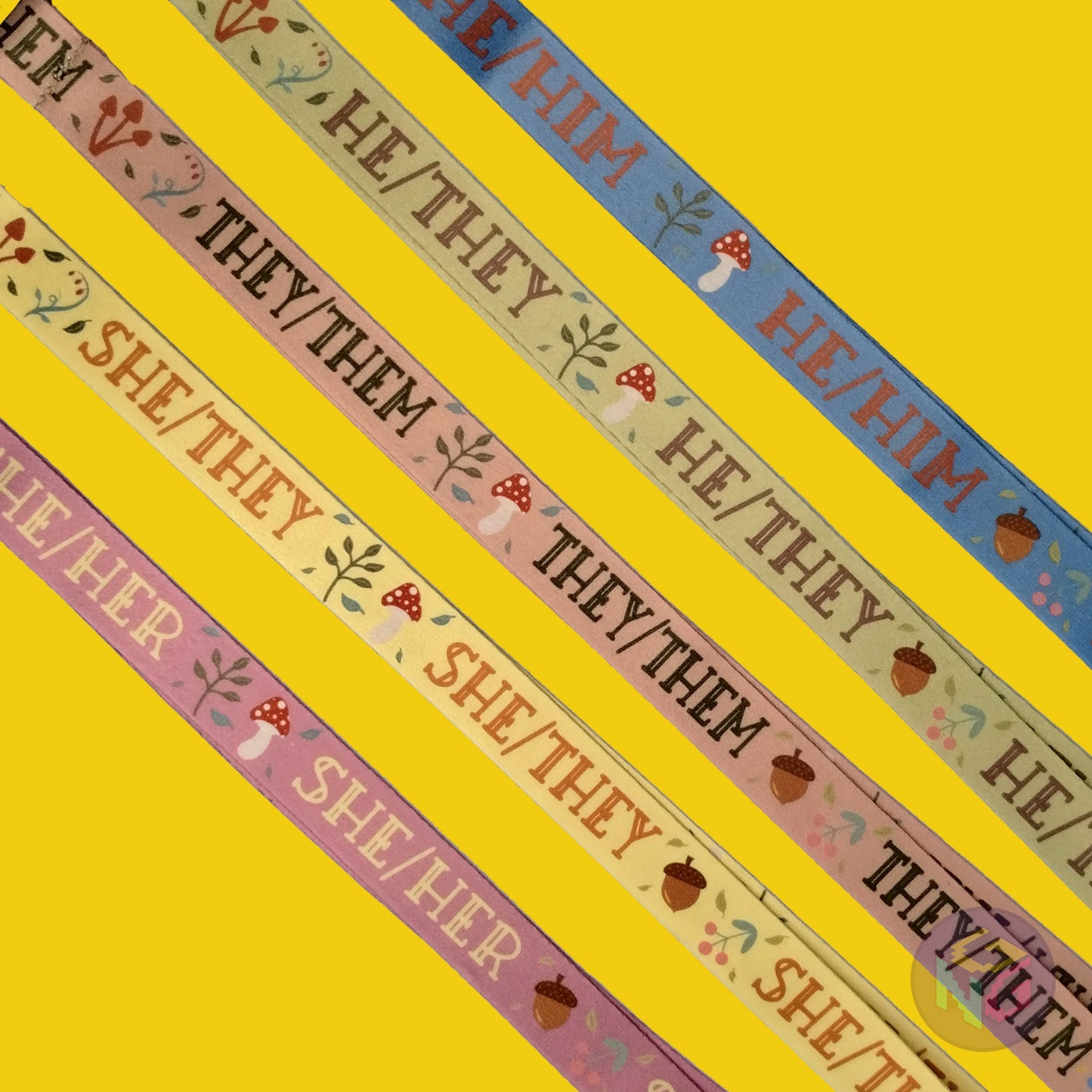 group shot of all five of the cottagecore pronoun lanyards showing the options for he him, he they, they them, she they, and she her