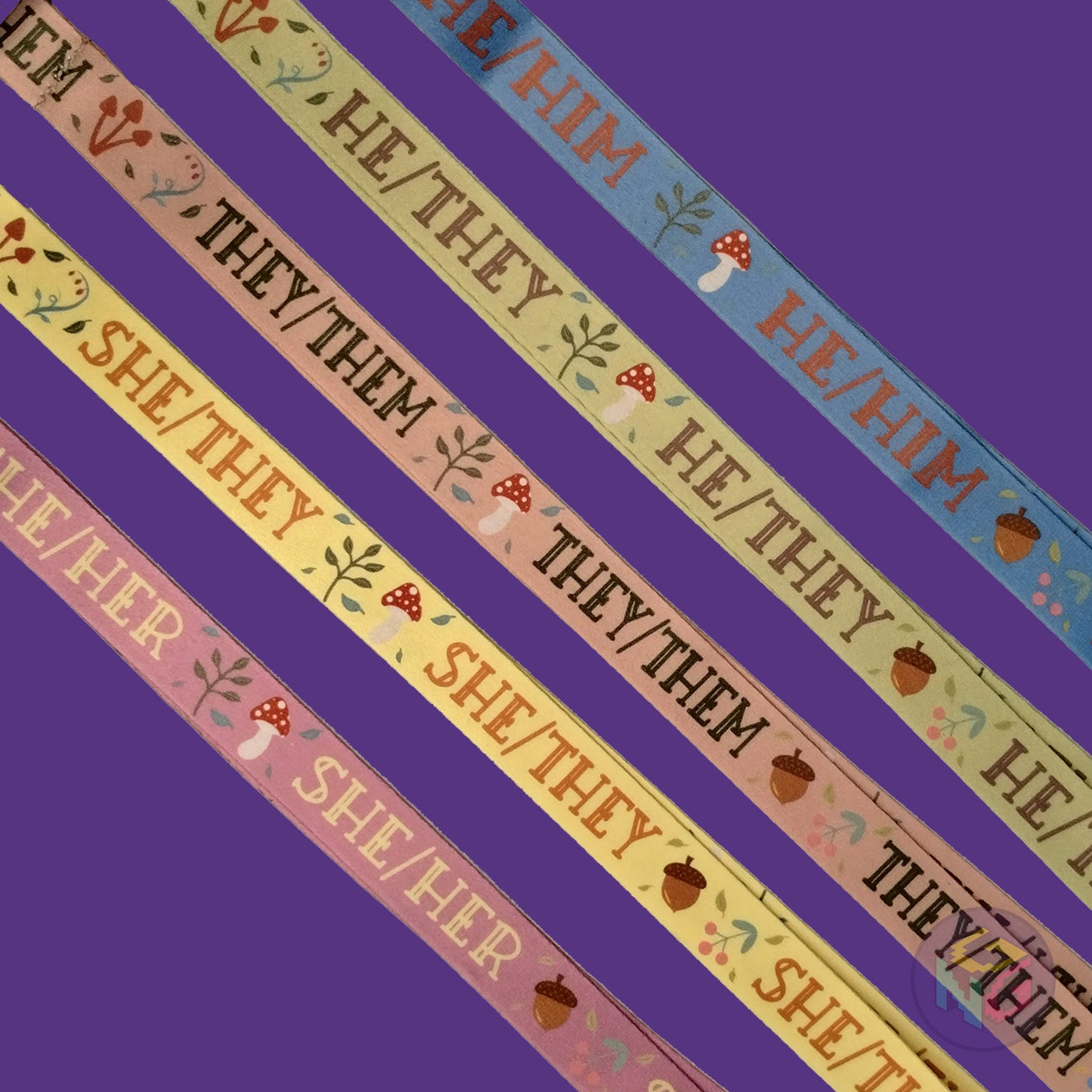 group shot of all five of the cottagecore pronoun lanyards showing the options for he him, he they, they them, she they, and she her