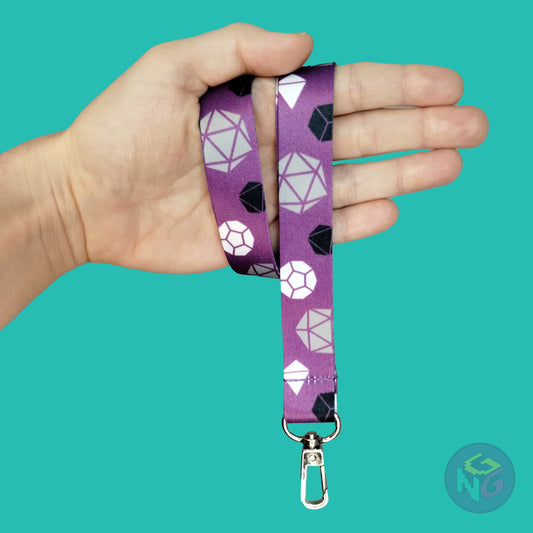 purple asexual dice lanyard wrapped around a hand with the lobster clasp dangling against a turquoise background