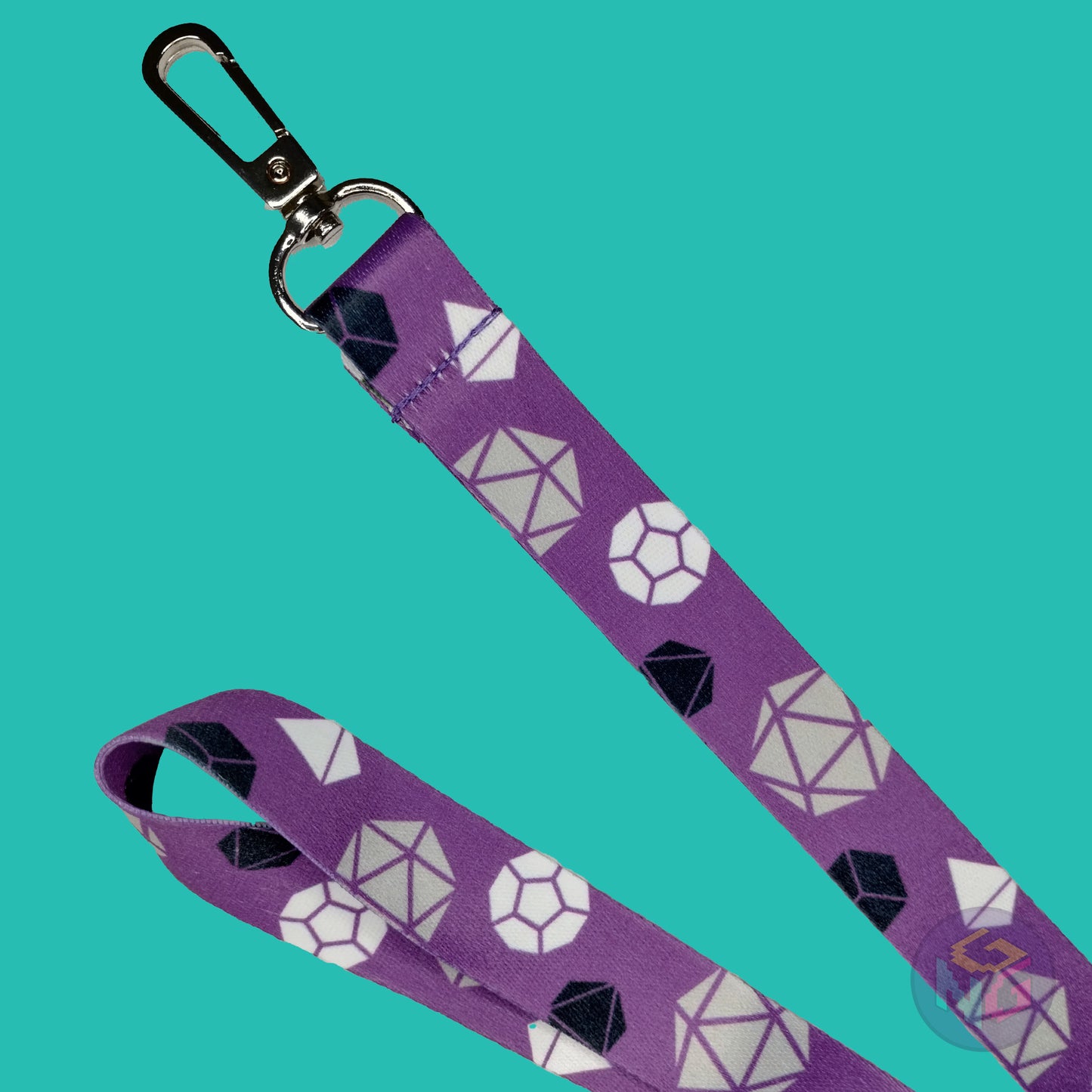 close up detail of the asexual dungeons and dragons lanyard showing the lobster clasp, grey d20s, black d6s, white d4s, and other dice
