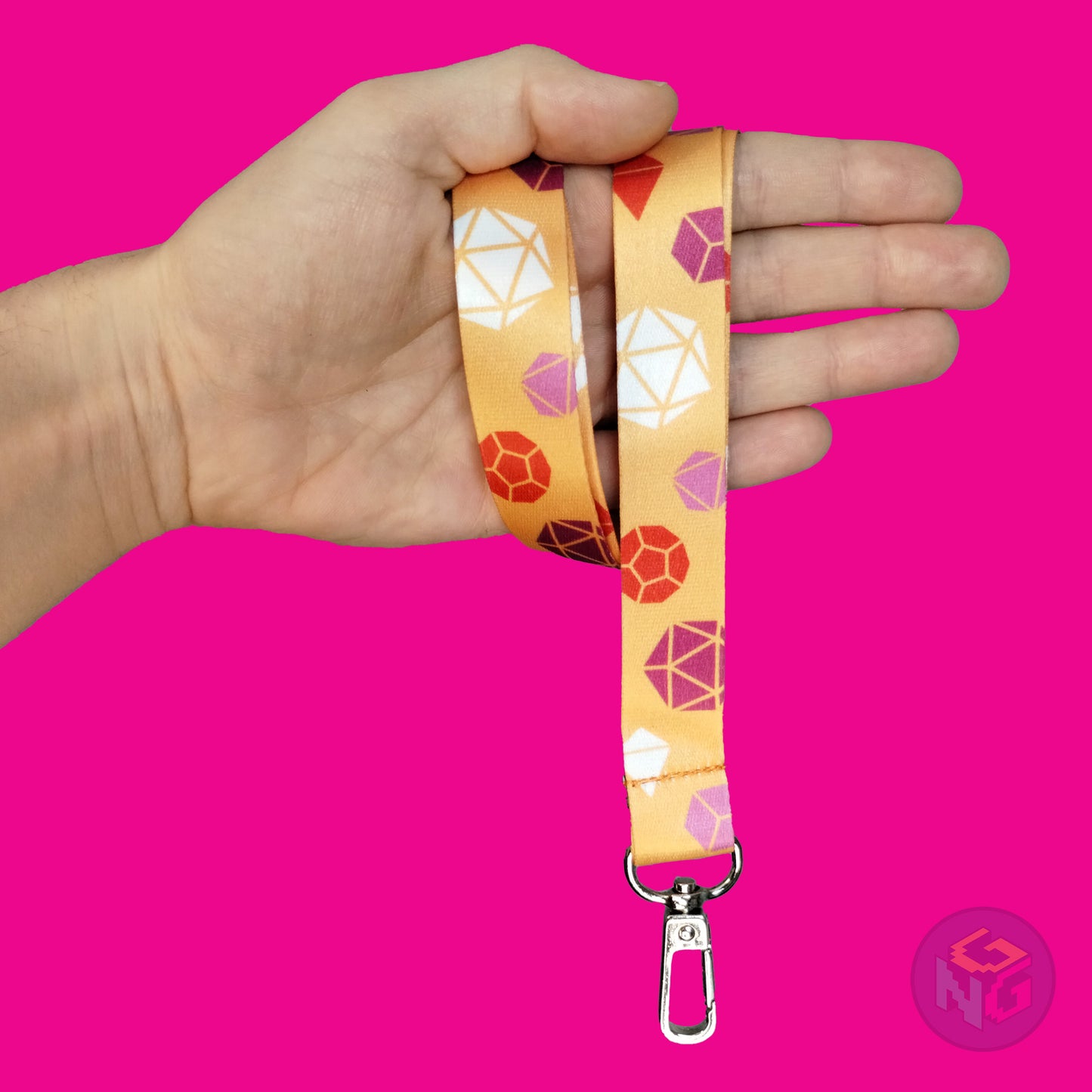 orange lesbian dice lanyard wrapped around a hand with the lobster clasp dangling against a hot pink background