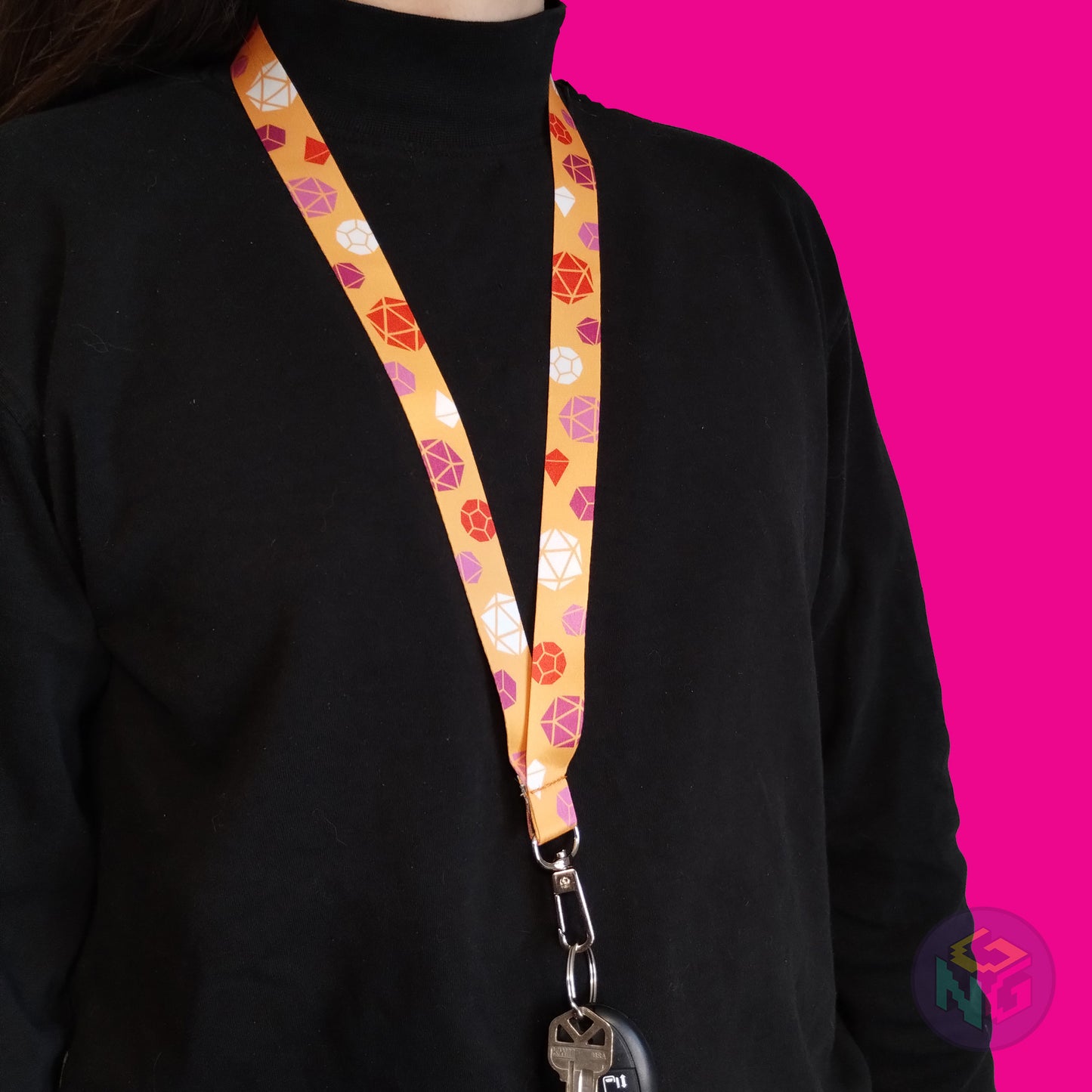 orange lesbian pride lanyard being worn by a flat chested person wearing a black turtleneck. The end of the lanyard falls between their sternum and bellybutton and has a key fob clipped to the end