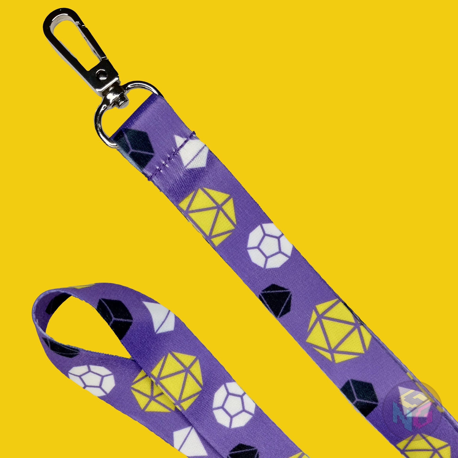 close up detail of the nonbinary dungeons and dragons lanyard showing the lobster clasp, yellow d20s, black d6s, white d4s, and other dice