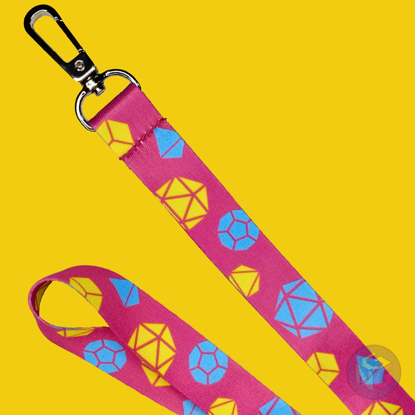 close up detail of the pansexual dungeons and dragons lanyard showing the lobster clasp, yellow d20s, blue d12s, and other dice