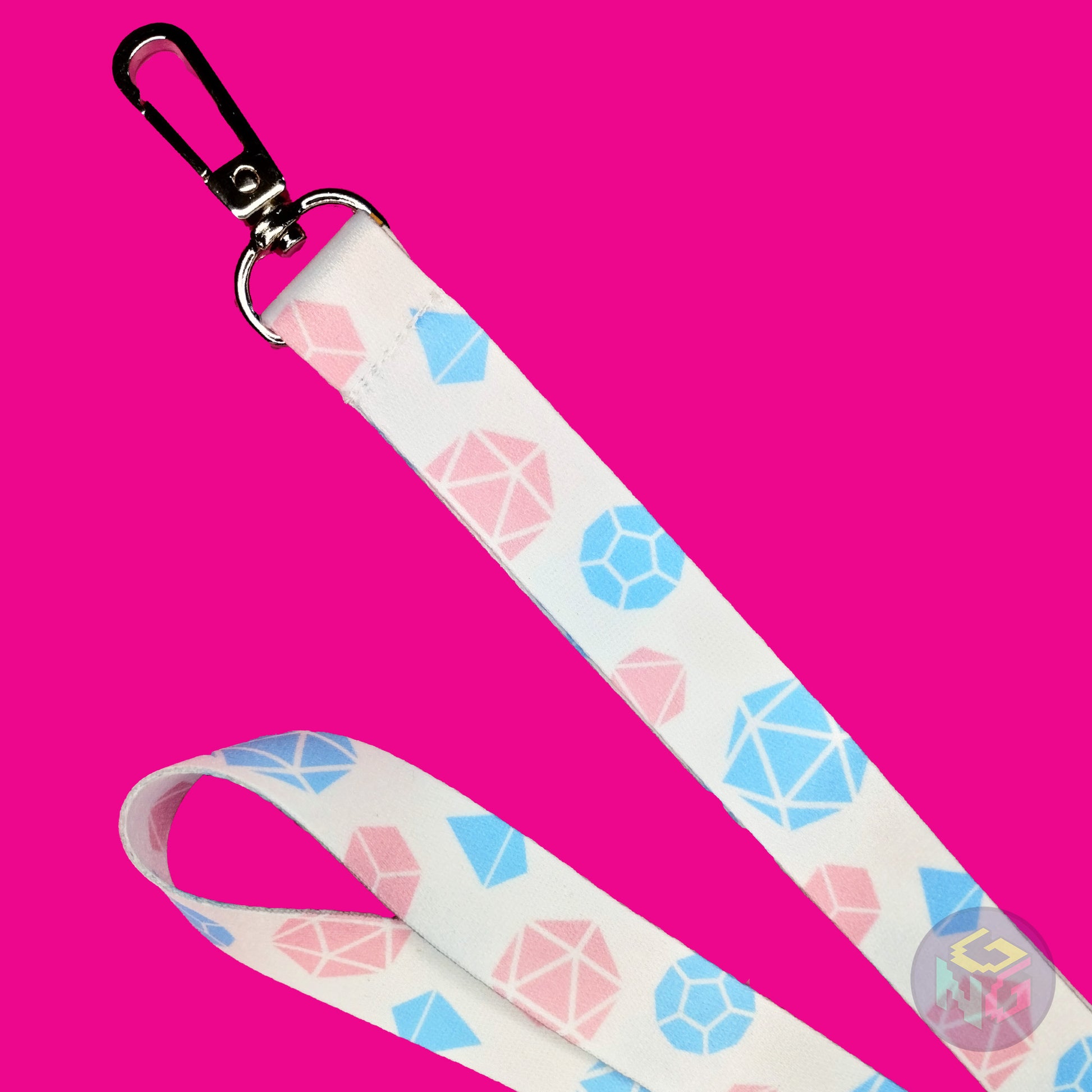 close up detail of the transgender dungeons and dragons lanyard showing the lobster clasp, pink d20s, blue d12s, and other dice