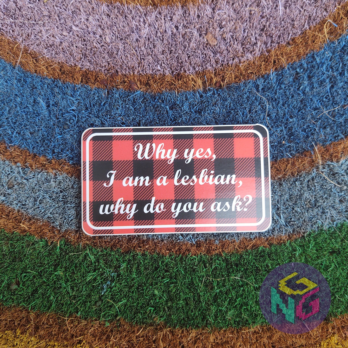 why yes i am a lesbian plaid sticker lying flat on rainbow welcome mat