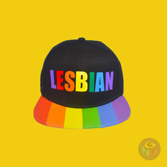 Black flat bill snapback hat. The brim has the rainbow pride flag on both sides and the front of the hat has the word “LESBIAN” in rainbow letters. Front view
