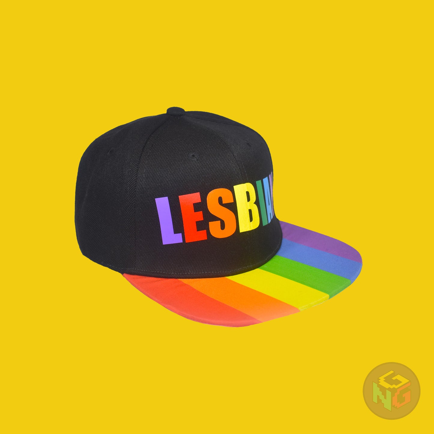 Black flat bill snapback hat. The brim has the rainbow pride flag on both sides and the front of the hat has the word “LESBIAN” in rainbow letters. Front right view
