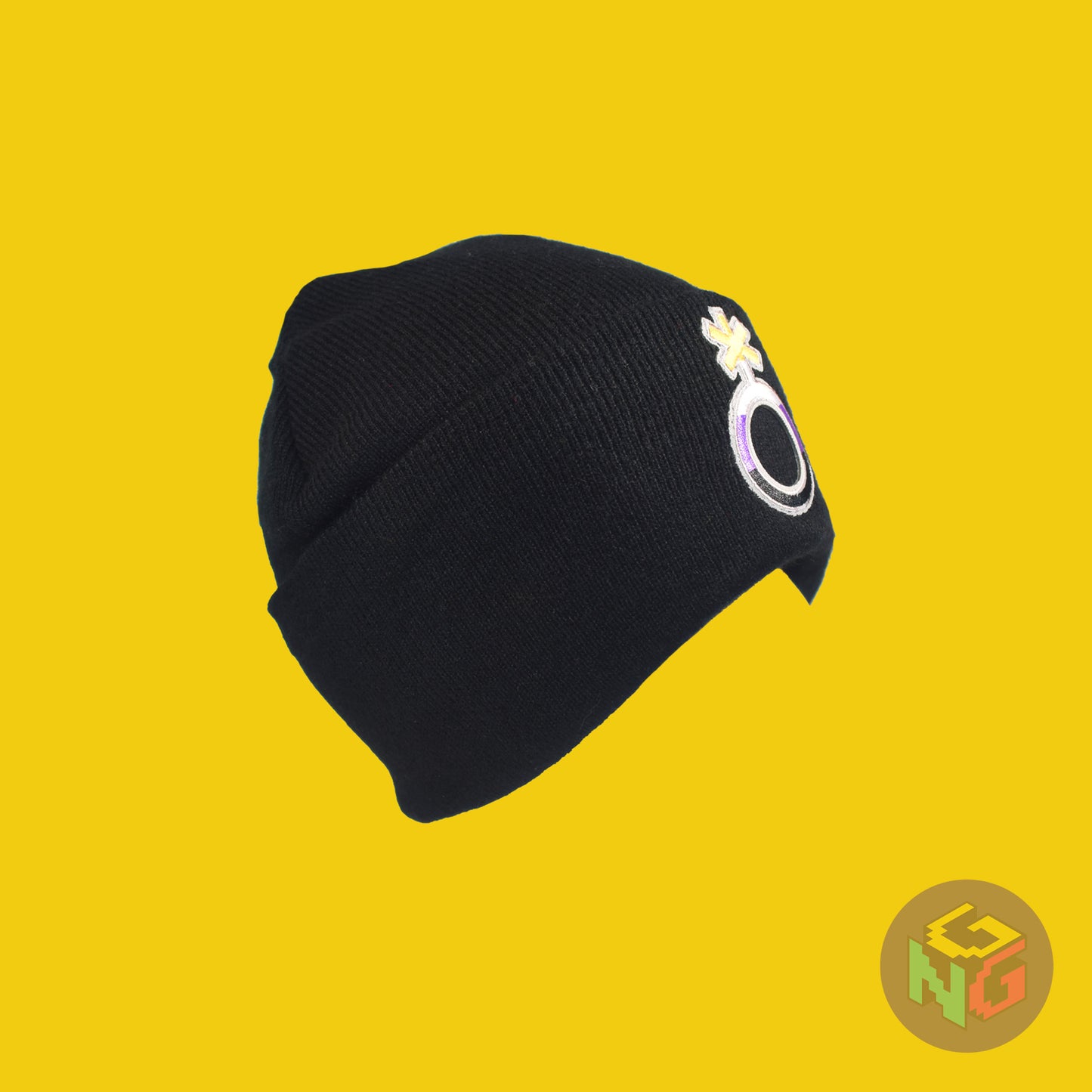 Black knit fabric beanie with the nonbinary symbol in yellow, white, purple, and black on the front. It is stretched and viewed from the side on a yellow background