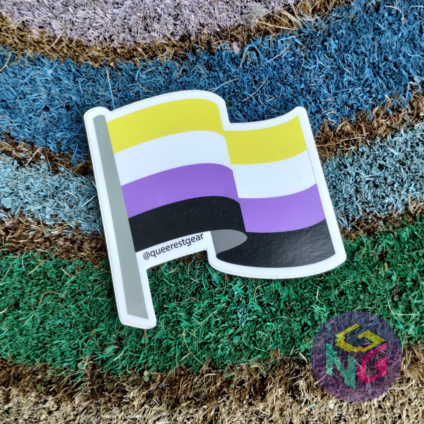 nonbinary flag sticker lying flat on rainbow welcome mat