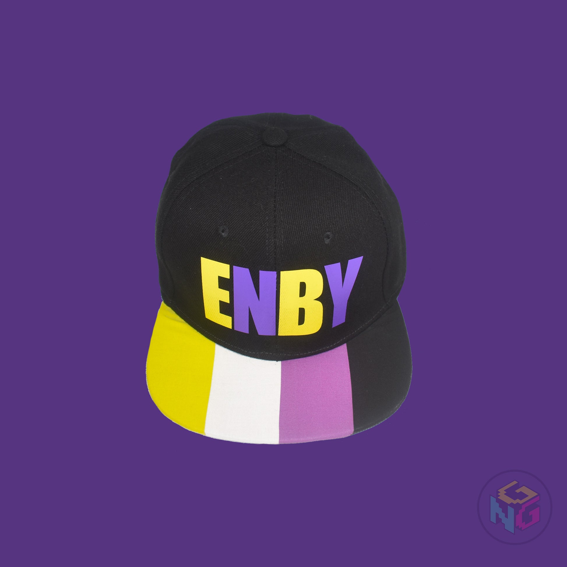 Black flat bill snapback hat. The brim has the nonbinary pride flag on both sides and the front of the hat has the word “ENBY” in yellow and purple letters. Front top view