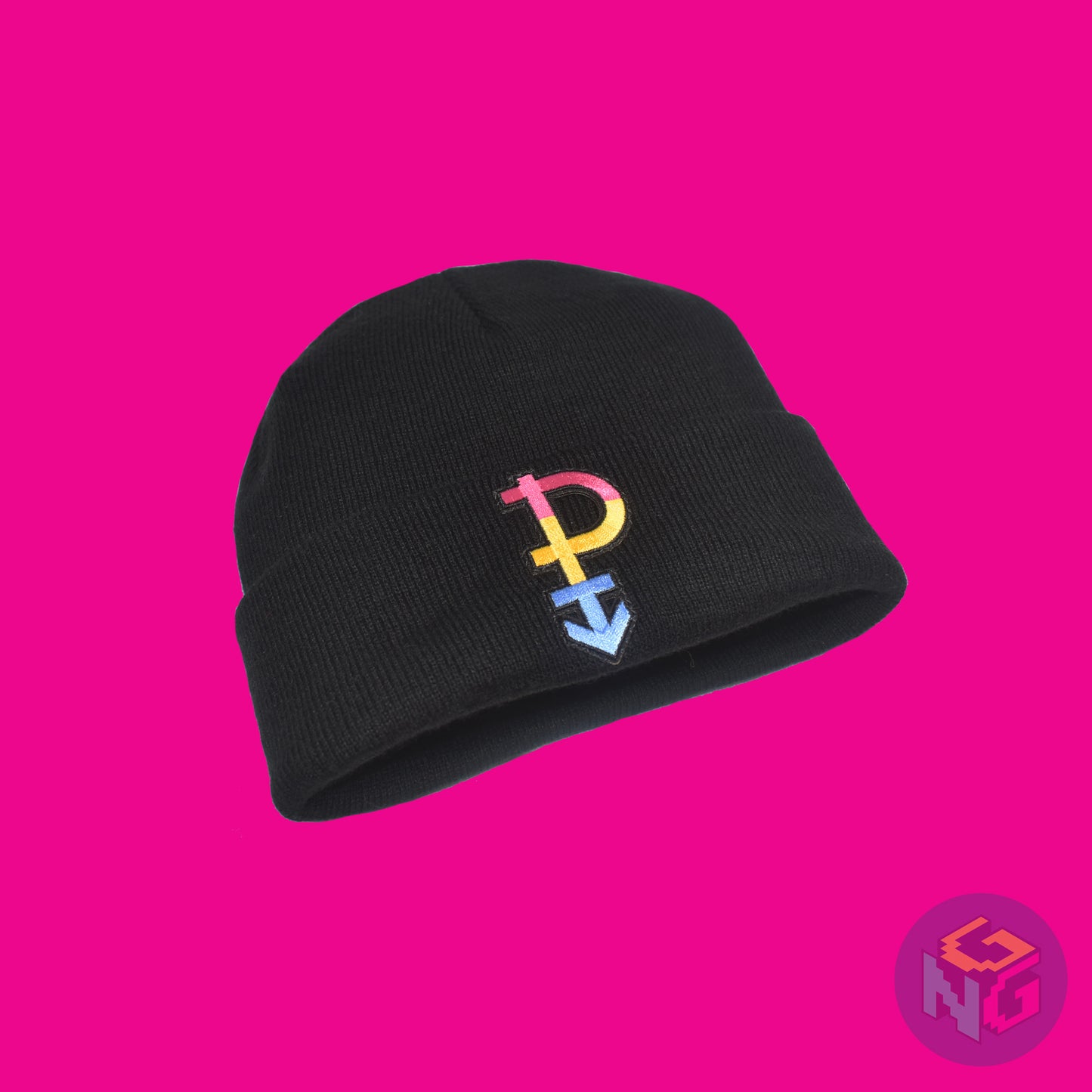 Black knit fabric beanie with the pansexual symbol in pink, yellow, and blue on the front. It is laying flat, seen from the lower left on a pink background